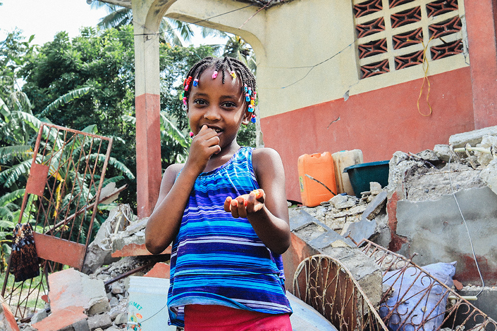 alt="Soraya_und_Ana_Soraya_vor_zerstörtem_Haus_Haiti_Erdbeben_Wiederaufbau_Compassion_Deutschland"
