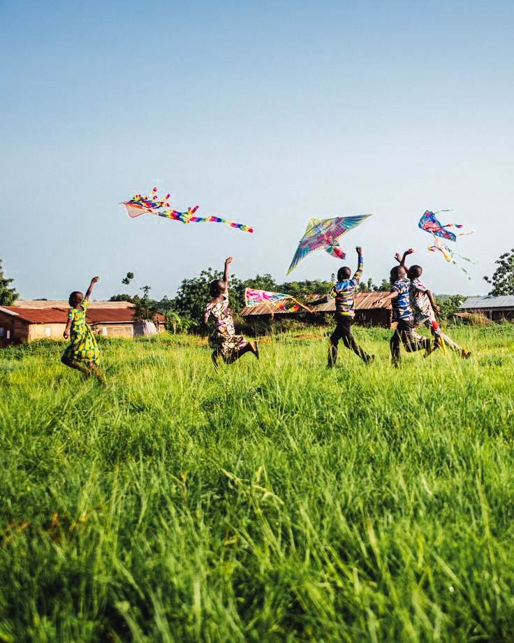 alt="Tag_gegen_Kinderarbeit_Kinder_spielen_mit_Drachen_auf_Wiese_in_Togo_gemeinsam_gegen_Kinderarbeit_Compassion_Deutschland"
